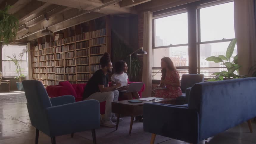 The people are talking together while sitting in the library