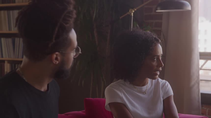 Man and woman talking while sitting on a couch
