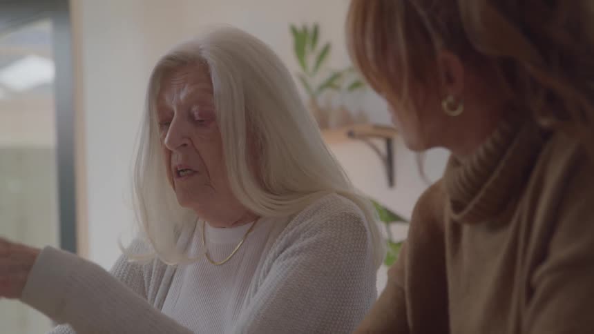 A young woman talks to an older woman in an indoor setting