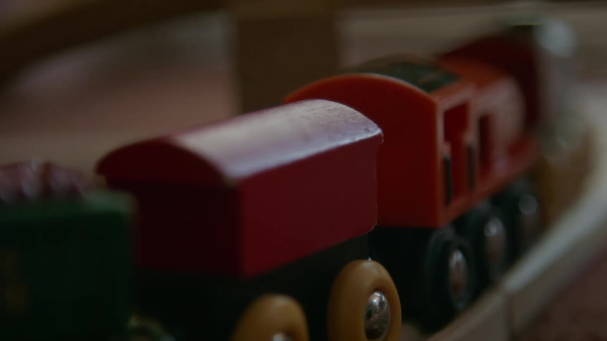 Wooden toy train with red wagons on tracks