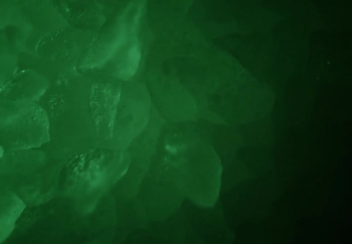 Ice cubes lit by green light in closeup