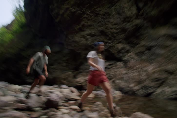 Two young people explore a canyon walking on the rocks