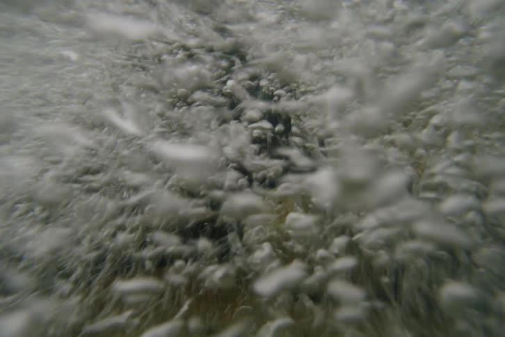 White bubbles swirling underwater create a whirl