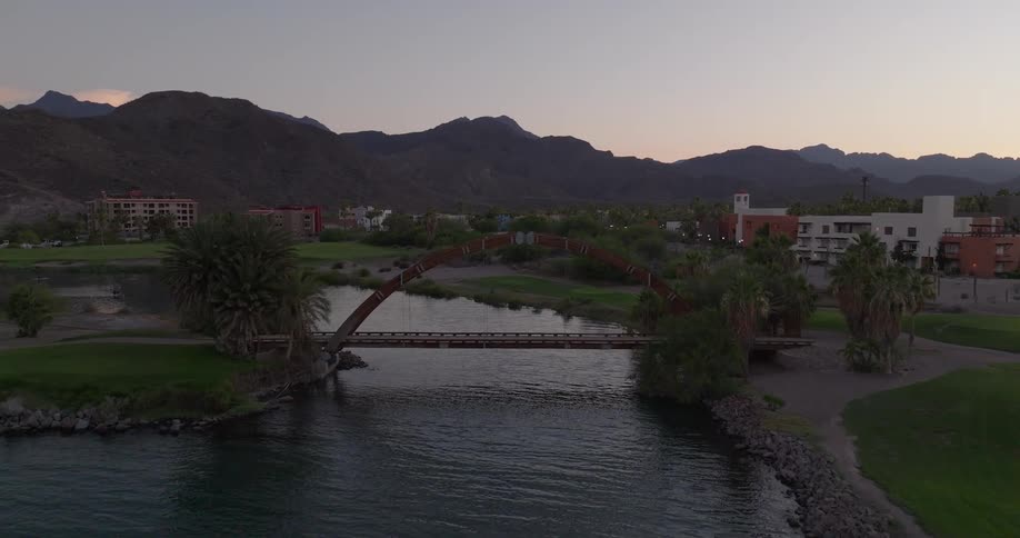 A camera pans over a body of water through several buildings up to the mountains