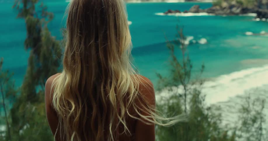 The woman runs down the hill to view the beach