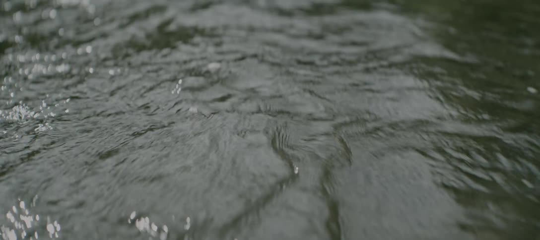 Closeup of water flowing through a river with a rippling surface