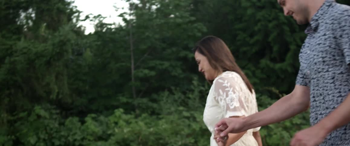 A man and woman hold hands as they run down a hill
