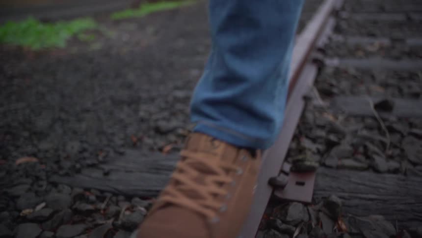 Person walking across the rail of a train track