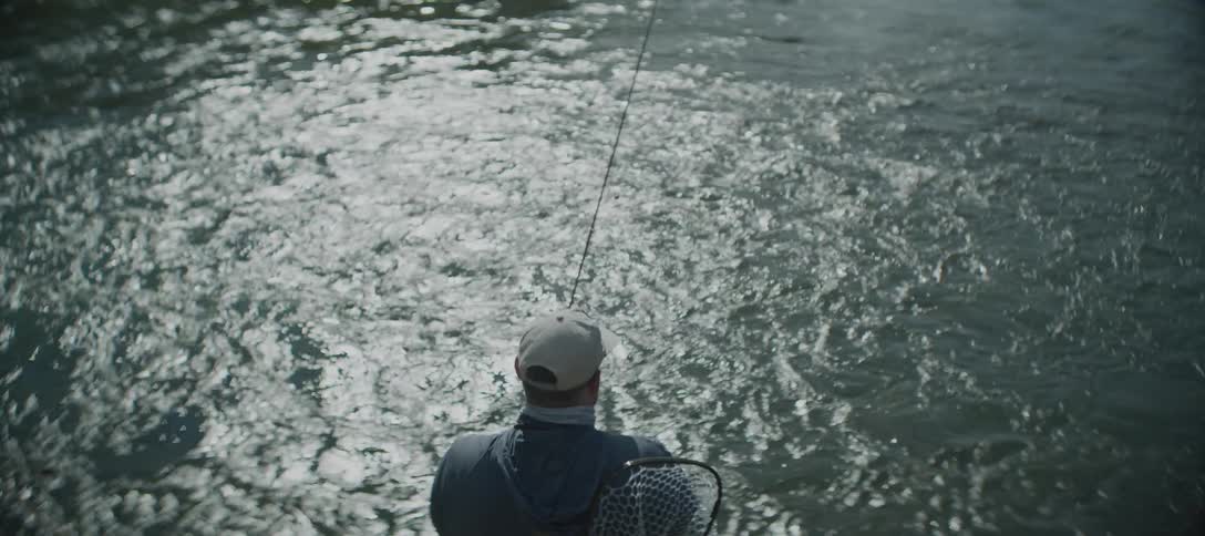 The man fly fishes in the rough water