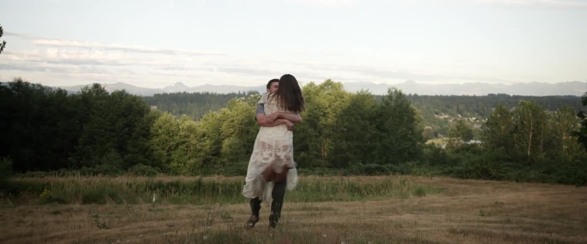 A man twirls a woman in his arms