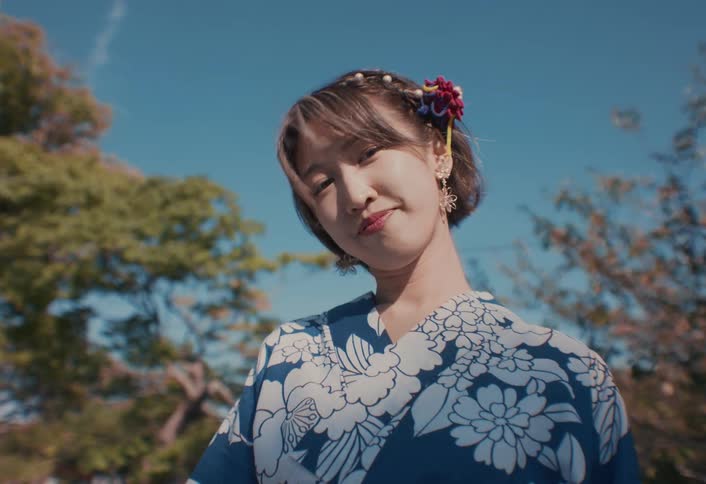 A Japanese woman in Yukata is smiling on a windy day