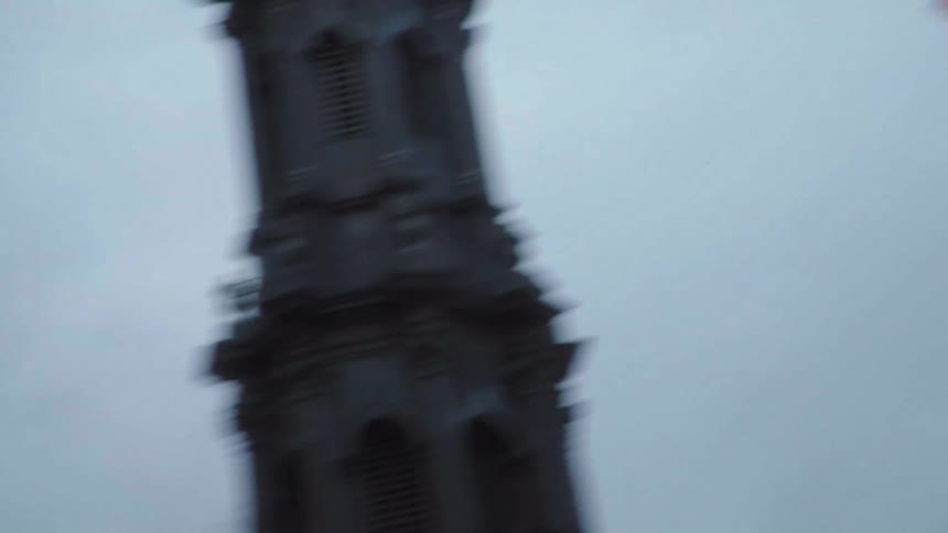 A camera moves through a city and shows a view of the buildings and the sky