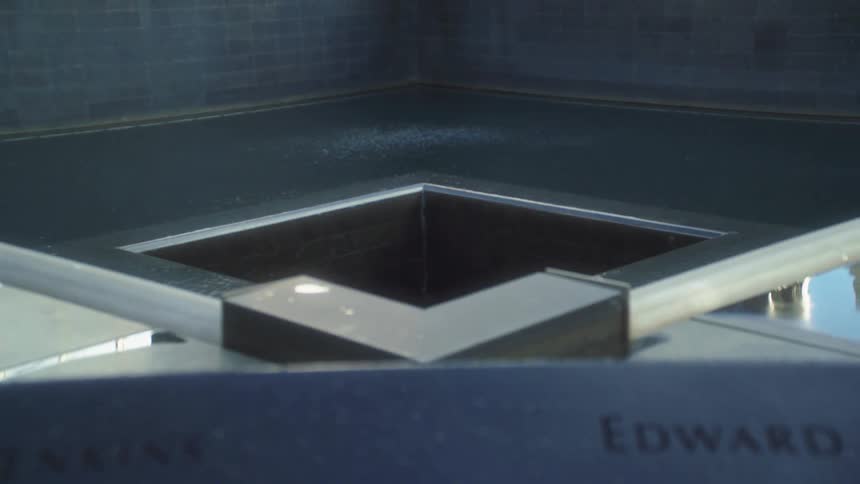 View of a memorial with a cascading fountain and engraved names around it