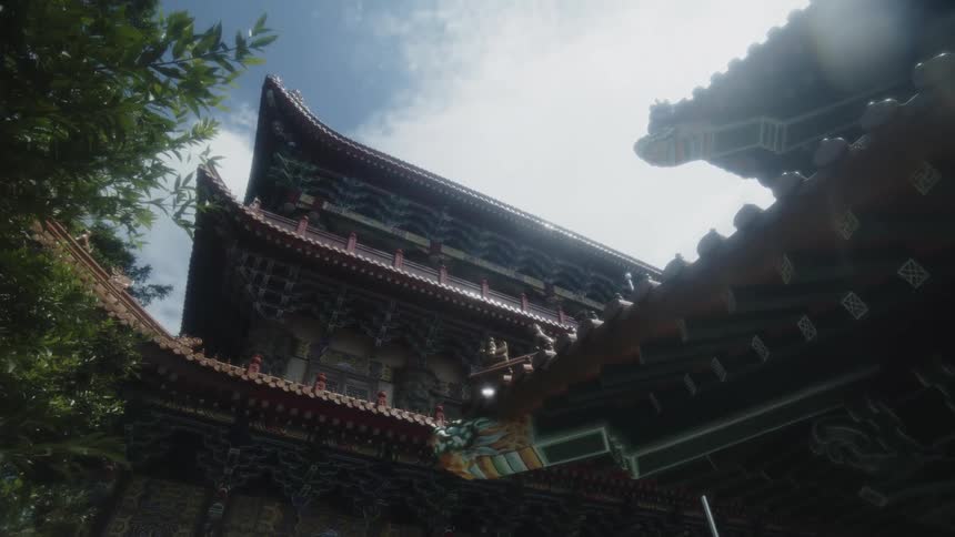 A building with native chinese roofing patterns at midday featuring curved eaves and ornate details a tree stands beside it casting soft shadows on the structure under the bright sunlight