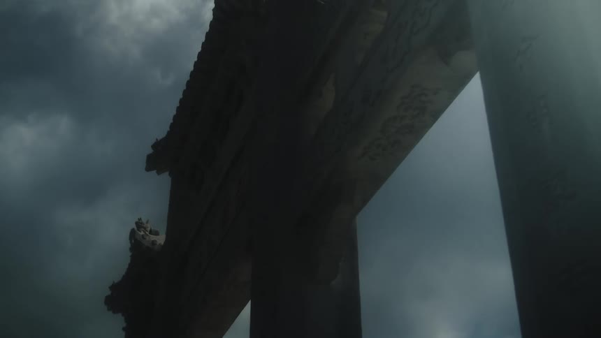 Clouds move across the sky above a stone archway