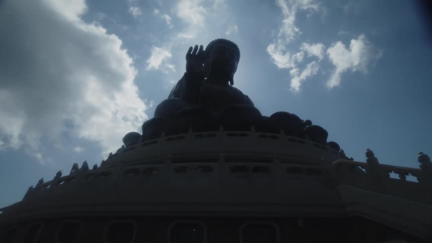 The sun shines over the large buddha statue
