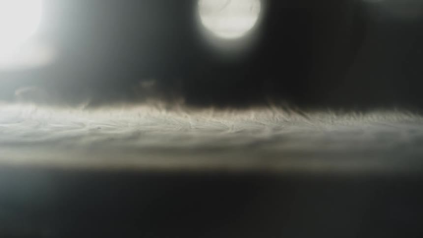 Blurred circular light hovers over softtoned abstract background with subtle central branding