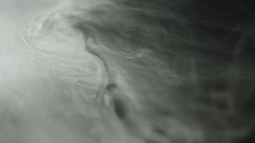 Swirls of light smoke spread in contrast with the dark background