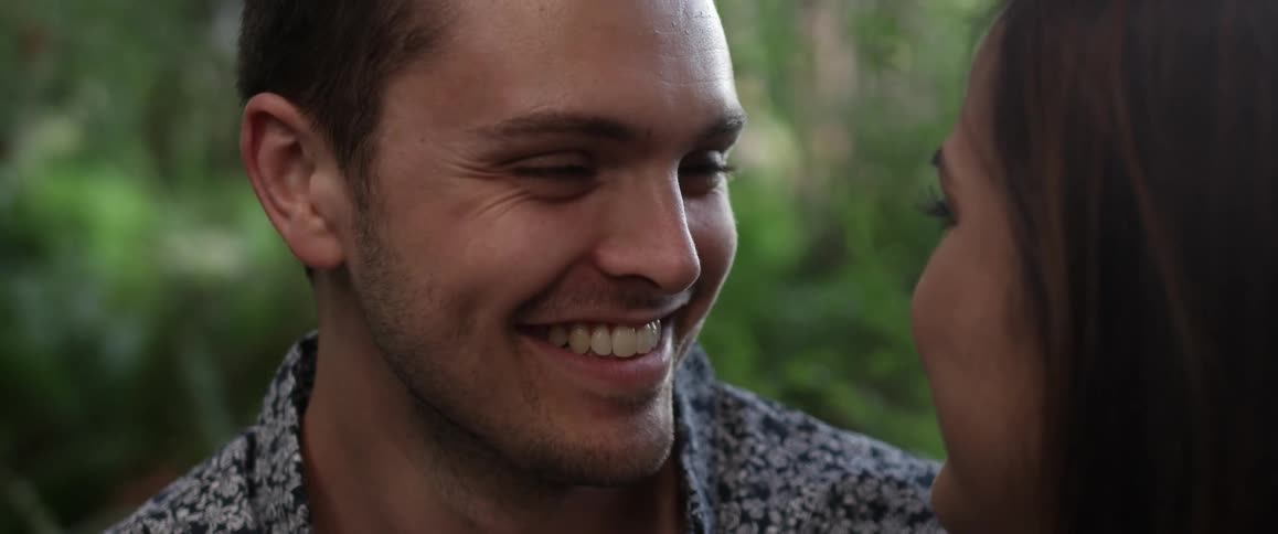 A man smiles at a woman outside