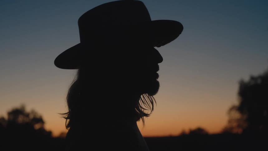 Contemplative silhouette stands out beneath a warmtoned sky as the day quietly fades away