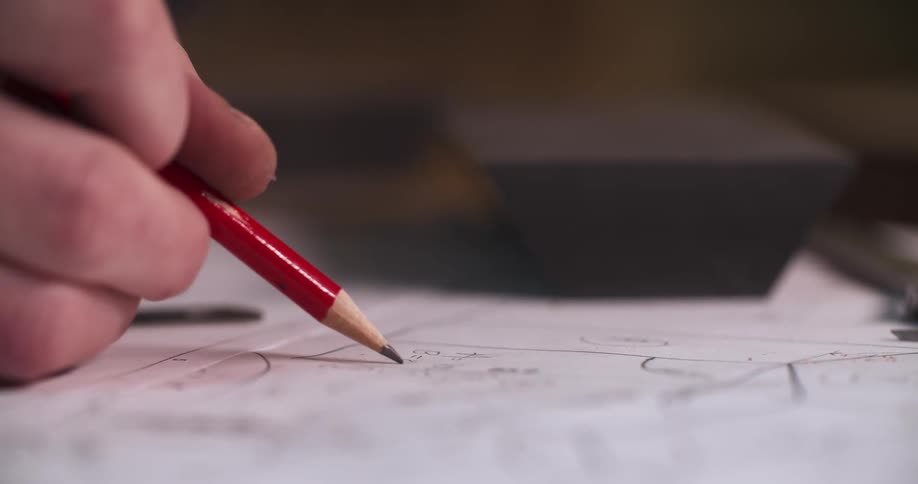 A person holds a pencil and writes on a piece of paper the scene is a close up in the hand writing