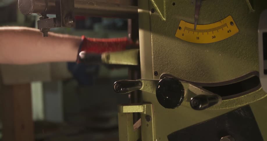 Close up of a man operating a machine in a workshop during daytime