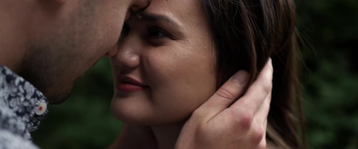 A woman smiles as a man holds her
