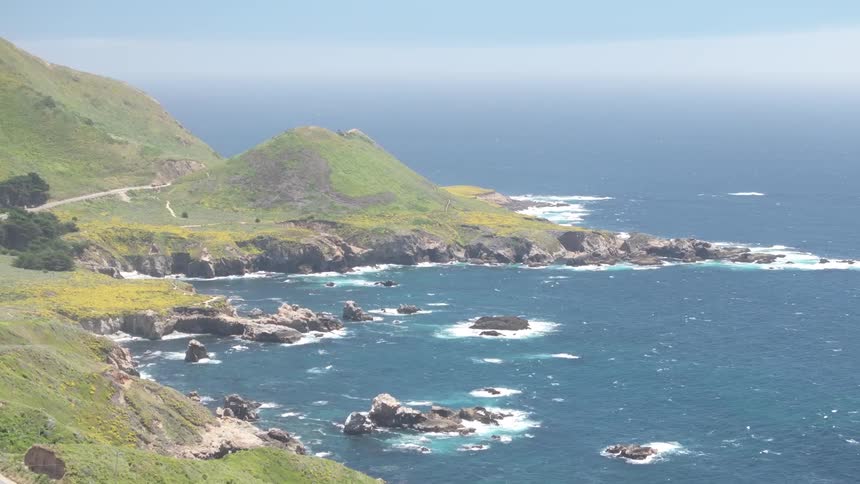 Rocky cliffs covered with vegetation along a coastline washed by blue waters