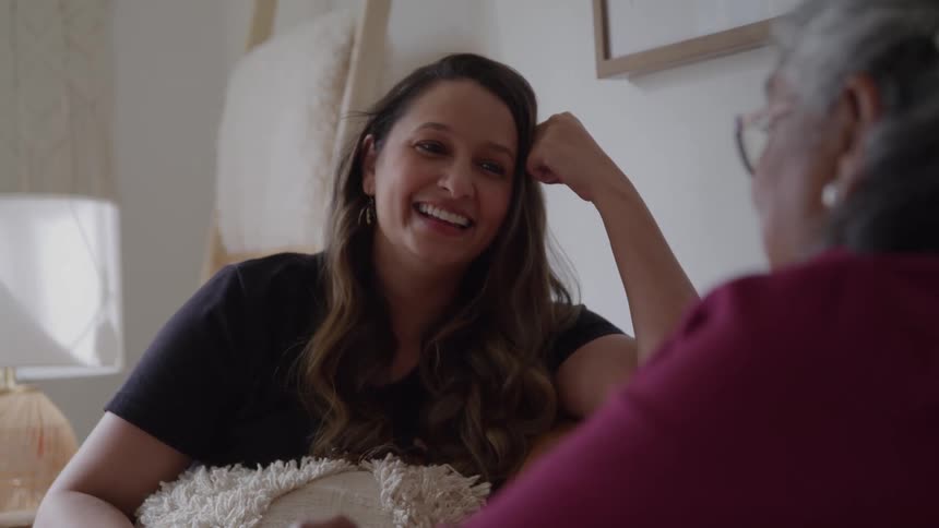 Woman smiles while chatting casually with an older person