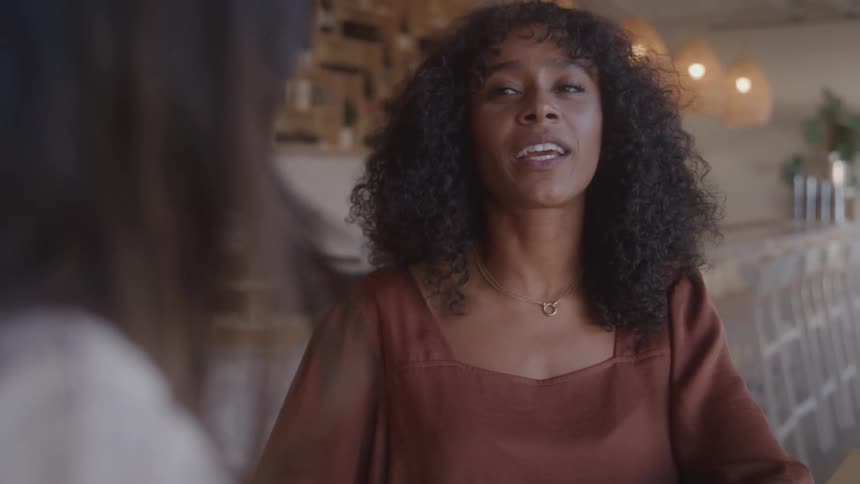 Curlyhaired woman smiles during a casual conversation