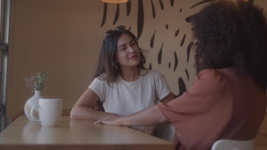 Two women talk and have coffee together