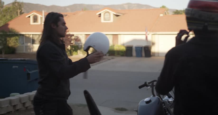 Man and woman put on motorcycle helmets before a ride
