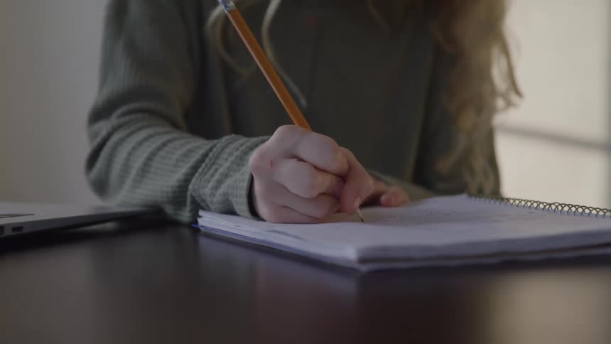 A girl writes in a notebook
