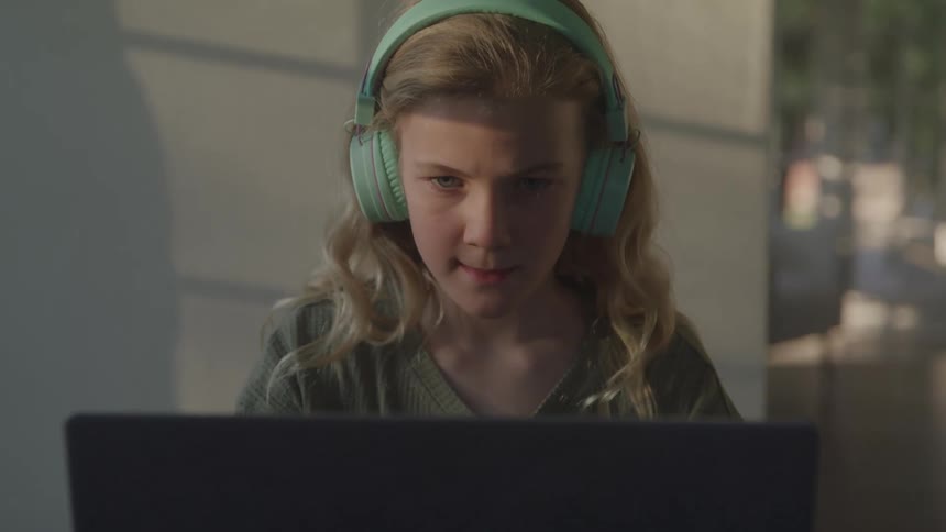A girl looks at her computer screen