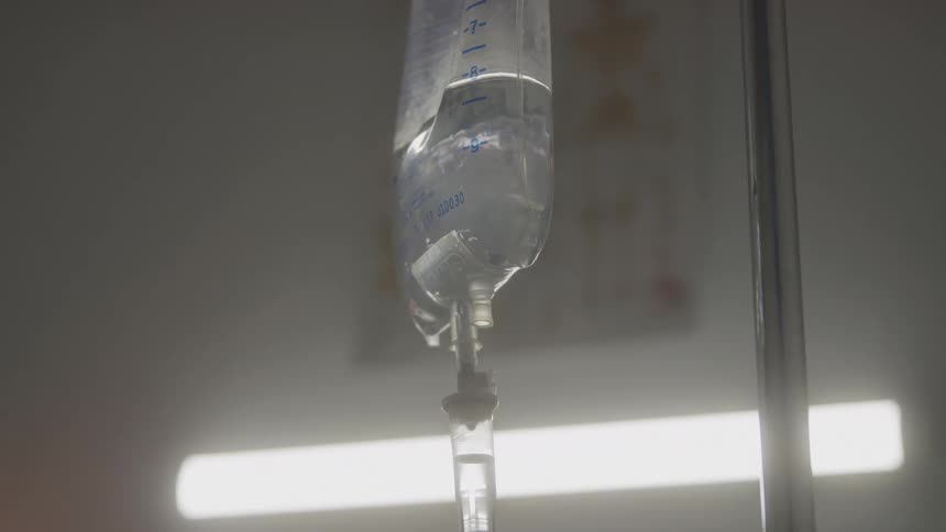 Iv bag hanging and slowly releasing liquid in a clinical setting