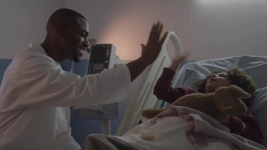 Doctor and child sharing a highfive in a hospital room