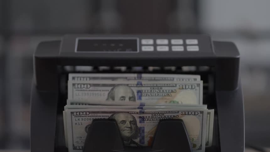 Counting machine displaying stacks of 100dollar bills at the intake