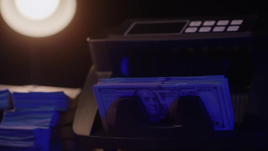 Machine in operation processes 100 bills with extra bundles positioned to the left