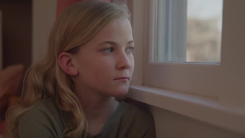 The girl turns her head to look out the window