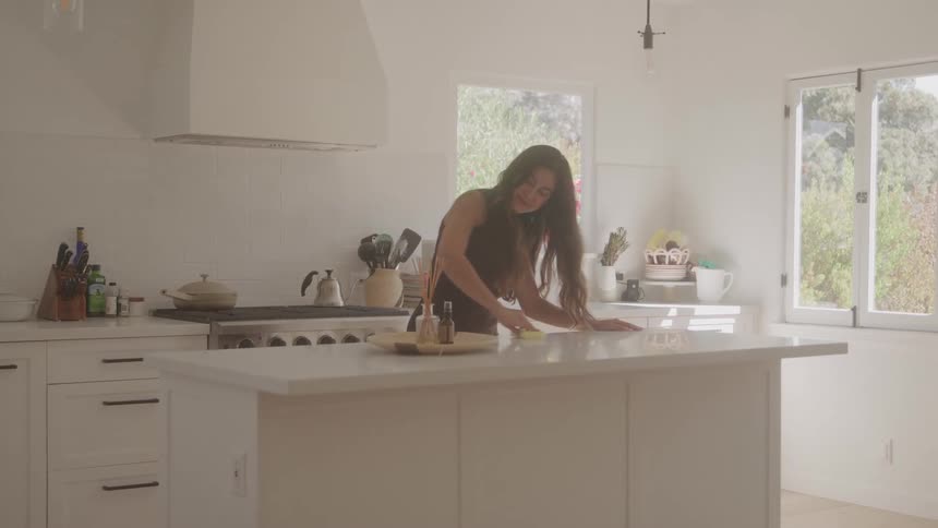The woman is cleaning up in the kitchen