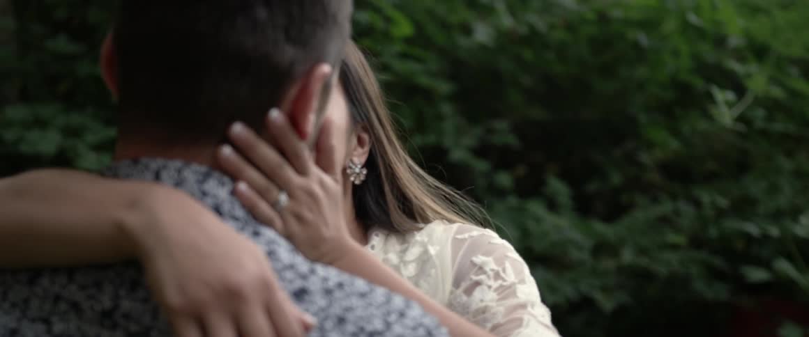 A man and woman are embracing and kissing in a natural setting