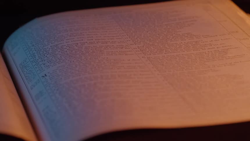 Open pages of an old book illuminated by soft warm light