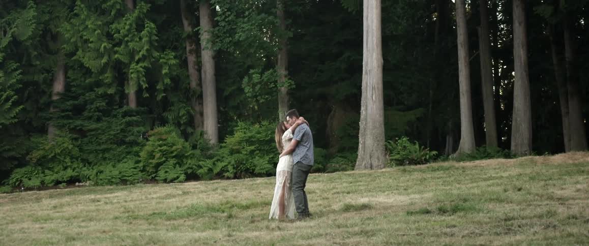 A man and woman walk towards each other by the forest