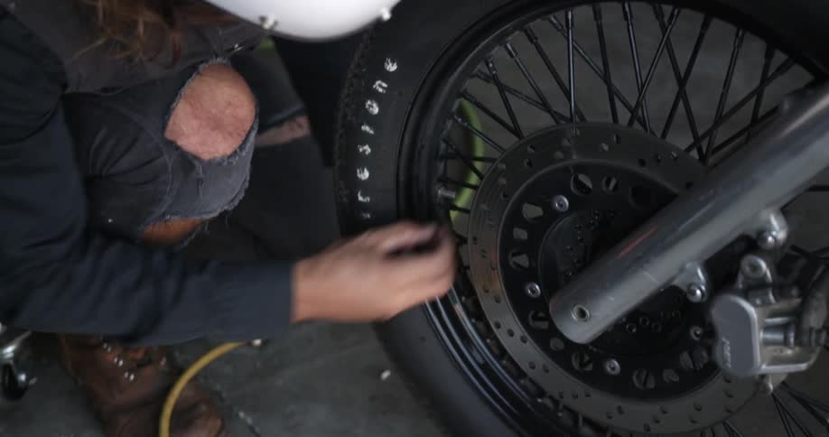 Person fills motorcycle tire up with air