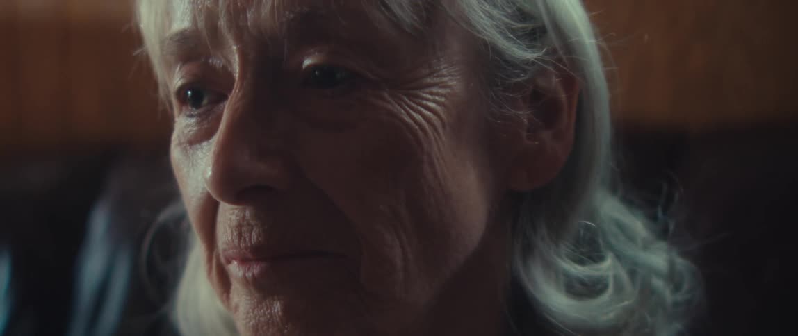 Close up portrait of a sad elderly woman sitting in a room during daytime