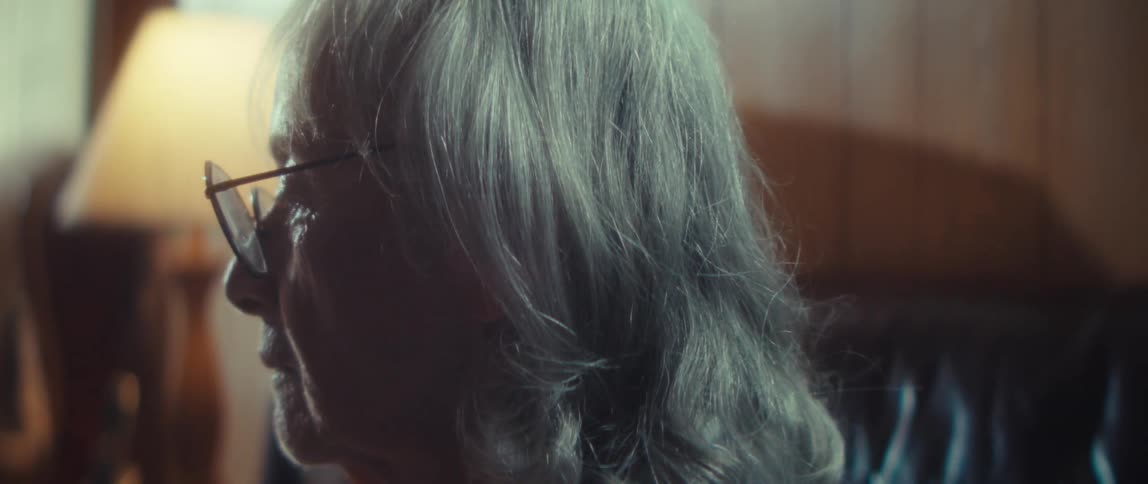 Closeup of an elderly woman sitting on a couch indoors