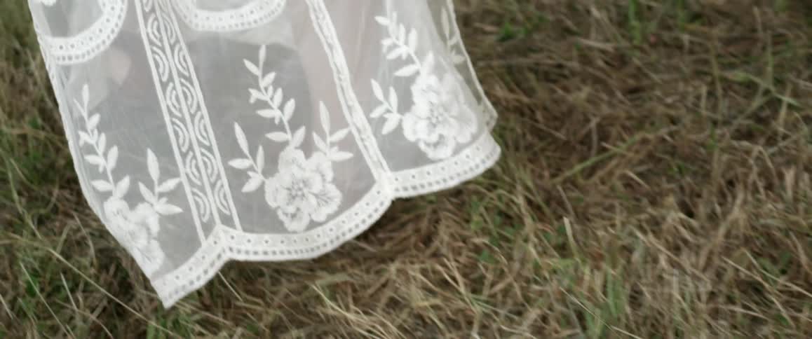 Lacy material swirls around the legs of a woman