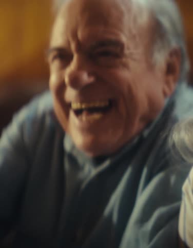Older man and female laughing openly eyes bright and face full of warm amusement