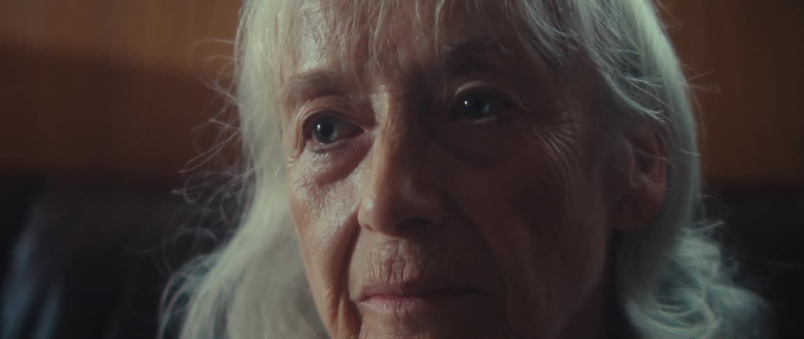 An elderly woman looks sad while staring and thinking