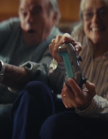 The woman tilts the controller while playing video games